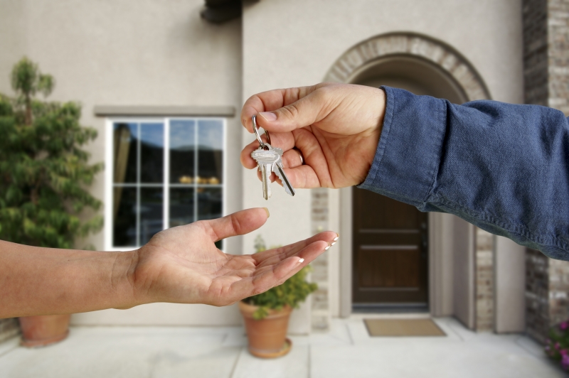 812327-handing-over-the-house-keys-in-front-of-new-home